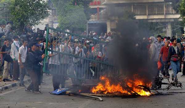 Massa pelajar membakar fasilitas umum saat  mengikuti unjuk rasa yang berujung ricuh di kawasan belakang gedung DPR,  Jalan Tentara Pelajar, Palmerah, Jakarta, Rabu (25/9/2019). Aksi tanpa tujuan yang jelas tersebut sebagian menggunakan seragam OSIS dan pramuka juga tampak menyanyikan yel-yel, menaiki pagar, memblokade jalan, bahkan melakukan aksi pemukulan terhadap polisi yang berjaga. (Foto: Berita Satu) 