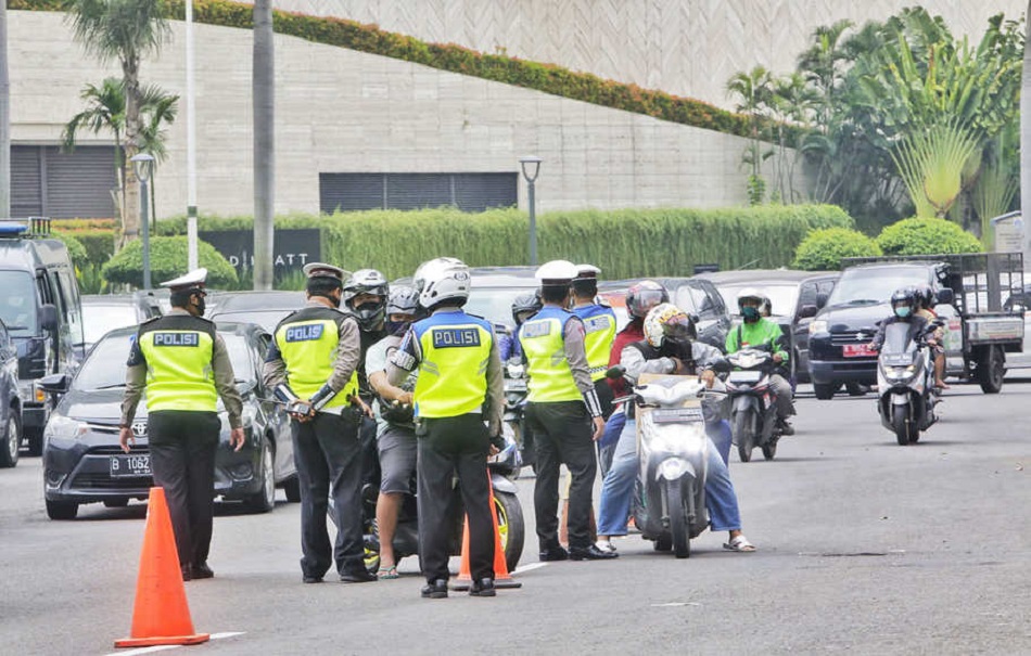 Polisi di kawasan Bundaran HI, Jakarta, melakukan pemeriksaan kepatuhan Pembatasan Sosial Berskala Besar (PSBB), Rabu (15/4/2020). © Suara Pembaruan