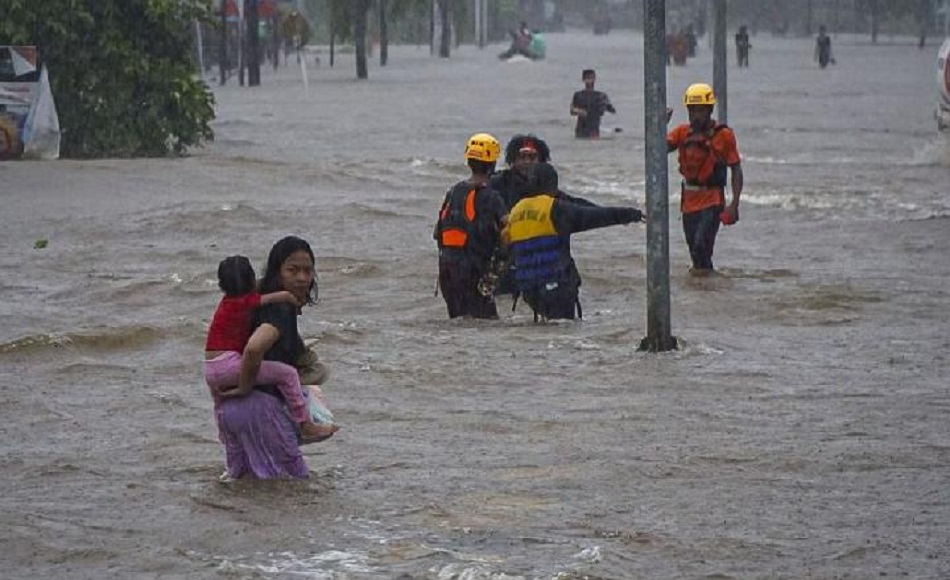 Sejumlah warga 'mengarungi' banjir yang merendam Jalan Lintas Melawi di Ladang, Kabupaten Sintang, Kalimantan Barat, Jumat 12 November 2021. (Foto: Antara)
