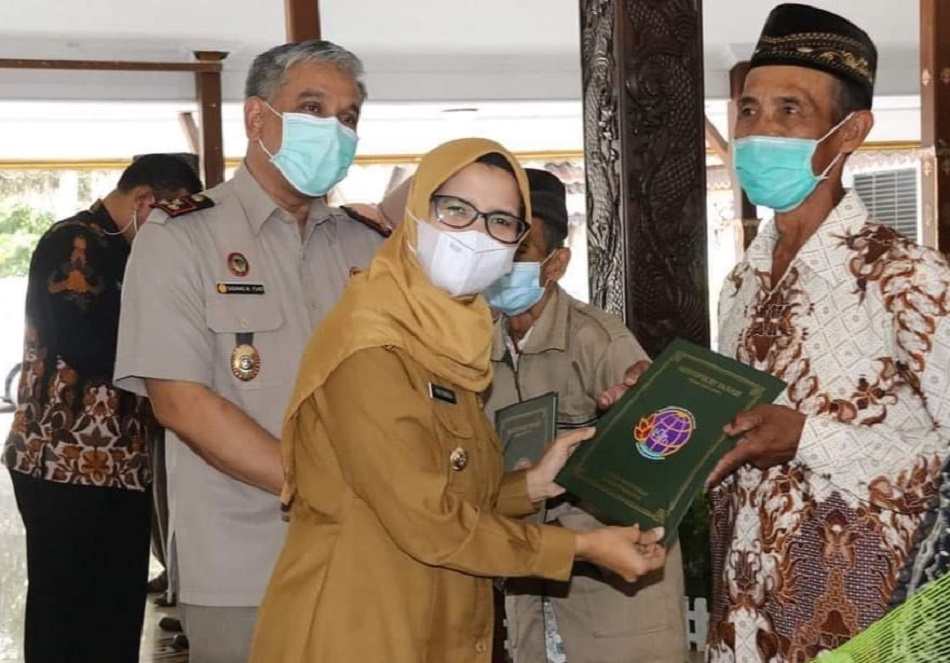 Bupati Blitar, Rini Syarifah didampingi Kepala BPB Kab Blitar, Dadang M Fuad menyerahkan sertifikat tanah redis Perkebunan Karangnongko kepada perwakilan warga. (Foto: Istimewa)