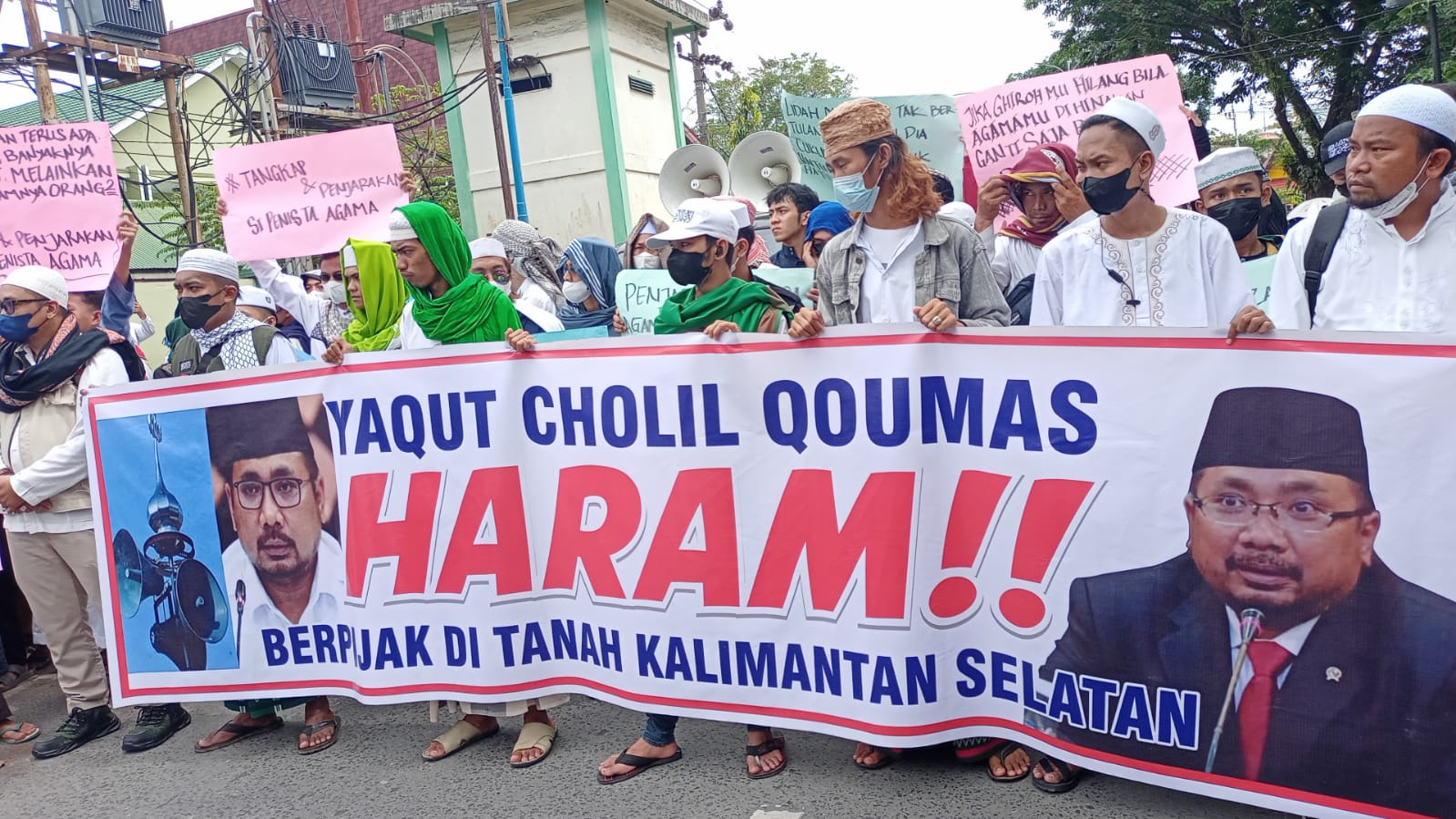 Massa aksi membentangkan spanduk 