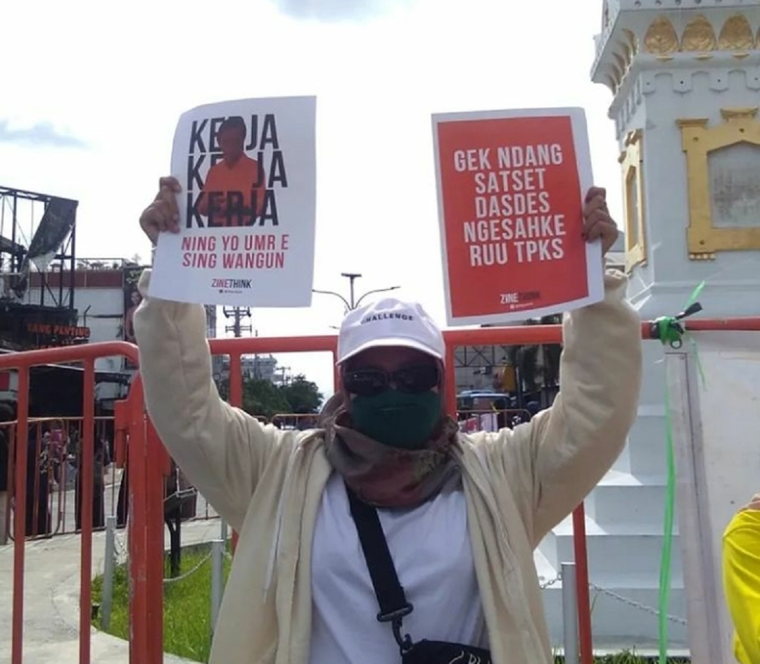 Seorang massa aksi Komite International Women’s Day Yogyakarta 2022 bentangkan poster dalam peringatan IWD di Tugu Jogja, Selasa (8/3). (Foto: Asalamia)