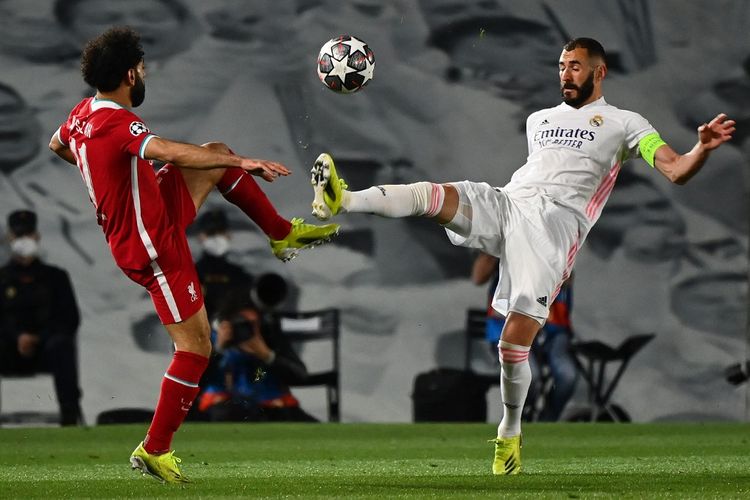 Mohamed Salah (kiri) dan Karim Benzema (kanan) berebut bola dalam pertandingan Real Madrid vs Liverpool di leg pertama perempat final Liga Champions 2020-2021. (Foto: AFP) 