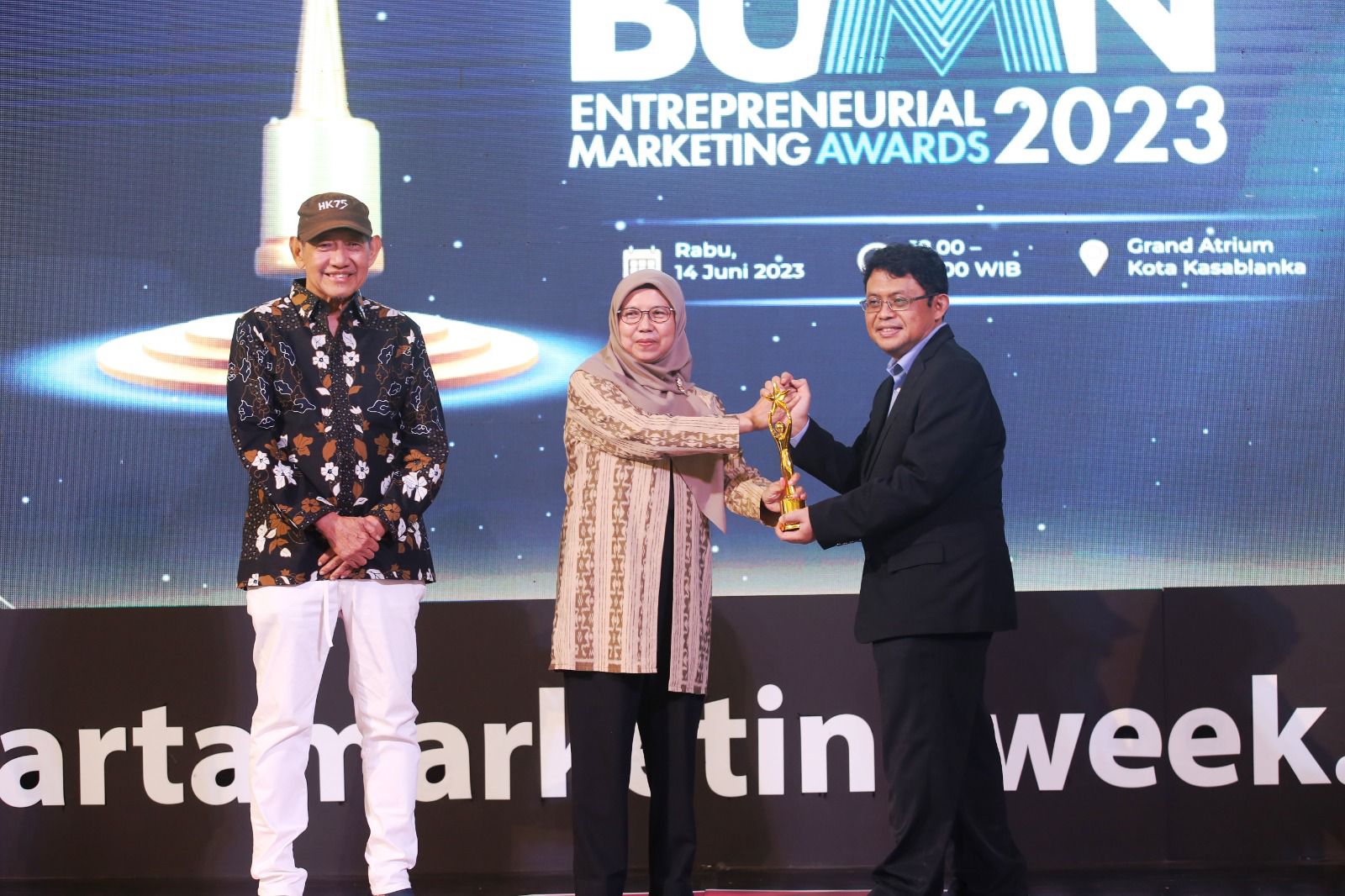 Direktur Retail dan Niaga PLN, Edi Srimulyanti (tengah) menerima piala penghargaan Best of The Best kategori BUMN pada ajang Entrepreneurial Marketing Awards 2023 yang diserahkan oleh Deputy CEO MarkPlus, Taufik (kanan) dan disaksikan oleh Founder & Chairman MarkPlus Corp, Hermawan Kartajaya (kiri). (Foto: PLN)