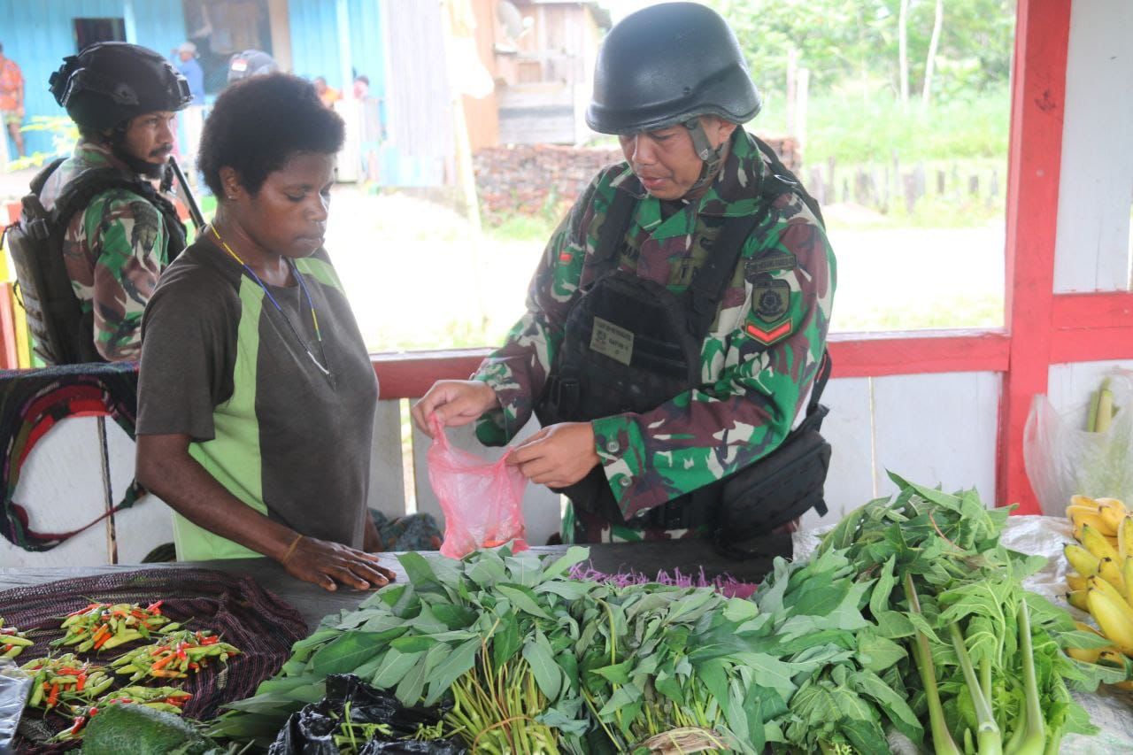Personel Satgas Mobile Yonif Mekanis Raider 411/Pandawa Kostrad memborong lapak jualan hasil bumi mama-mama Papua (Distrik Krepkuri) di Pasar Rakyat, Kampung Mumugu, Distrik Sawa Erma, Kabupaten Asmat, Rabu (23/8/2023). (Foto: Istimewa) 