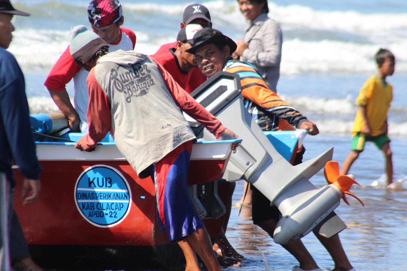 Nelayan di Pantai Teluk Penyu, Cilacap gotong royong mendorong kapal bermesin listrik untuk digunakan mencari ikan. (Foto: Istimewa) 