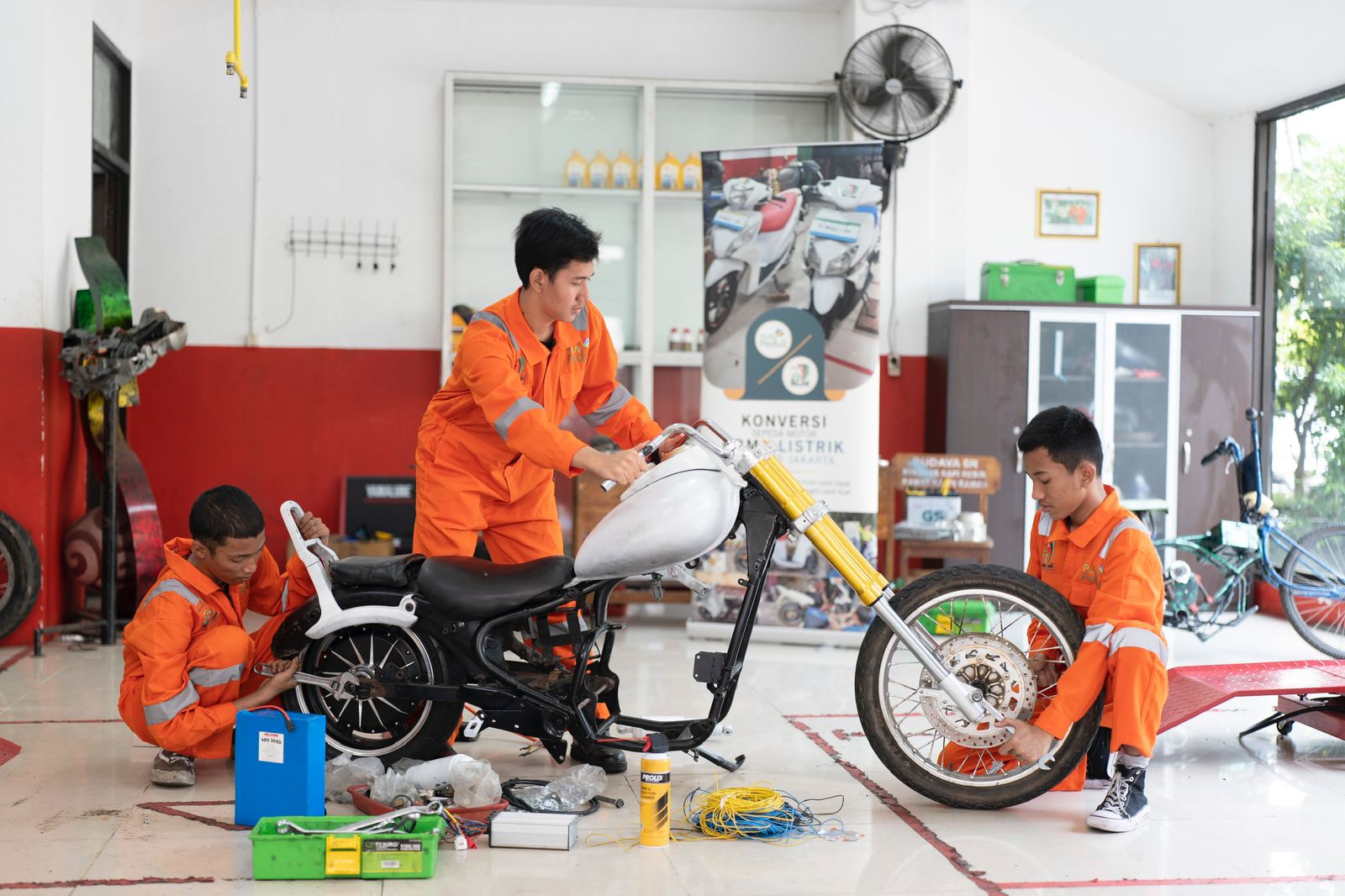 Siswa Sekolah Menengah Kejuruan Negeri (SMKN) 55 Jakarta sedang memodifikasi motor berbahan bakan minyak (BBM) menjadi motor berbahan bakar listrik. (Foto: Istimewa) 