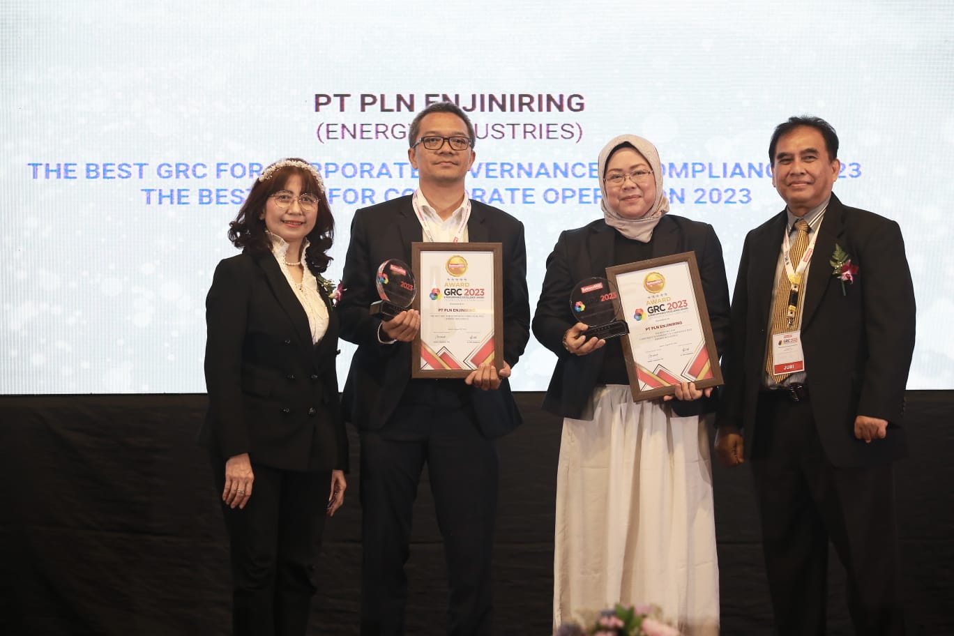 Dewan juri GRC & Performance Excellence Award 2023, Dr. Eddy Iskandar (kanan) dan Dr. Dewi Hanggraeni (kiri) menyerahkan penghargaan kepada Kepala Satuan Manajemen Mutu dan Risiko PLN Enjiniring, Hanung Natendra Sukandrio (kedua dari kiri) dan Sekretaris Perusahaan PLN Enjiniring, Katherine Amaranila (kedua dari kanan). (Foto: Istimewa) 