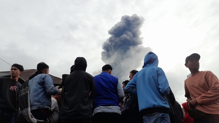 Sejumlah warga menyaksikan kondisi terkini erupsi Gunung Marapi yang terjadi sejak Minggu (3/12/2023) sore. (Foto: Radar Sumber)