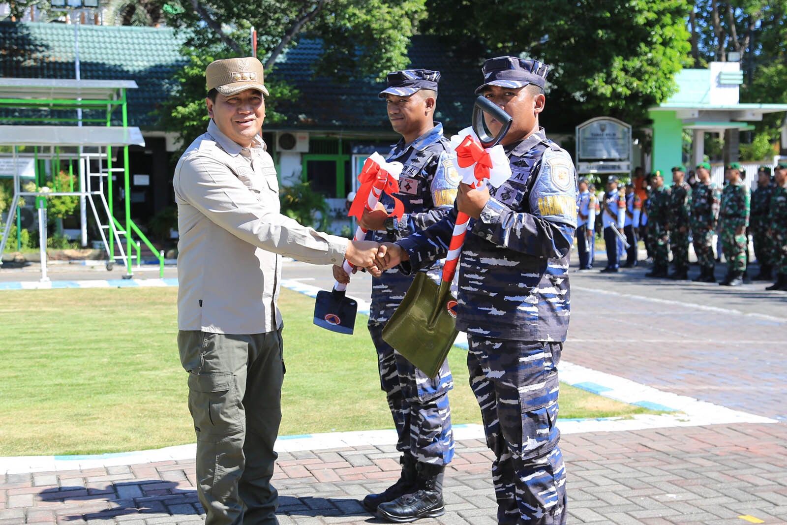 Pj Wali kota Probolinggo Nurkholis menyerahkan sekop kepada TNI AL dalam program karya bakti TNI AL, Kamis (11/7/2024). (Foto: Antara) 
