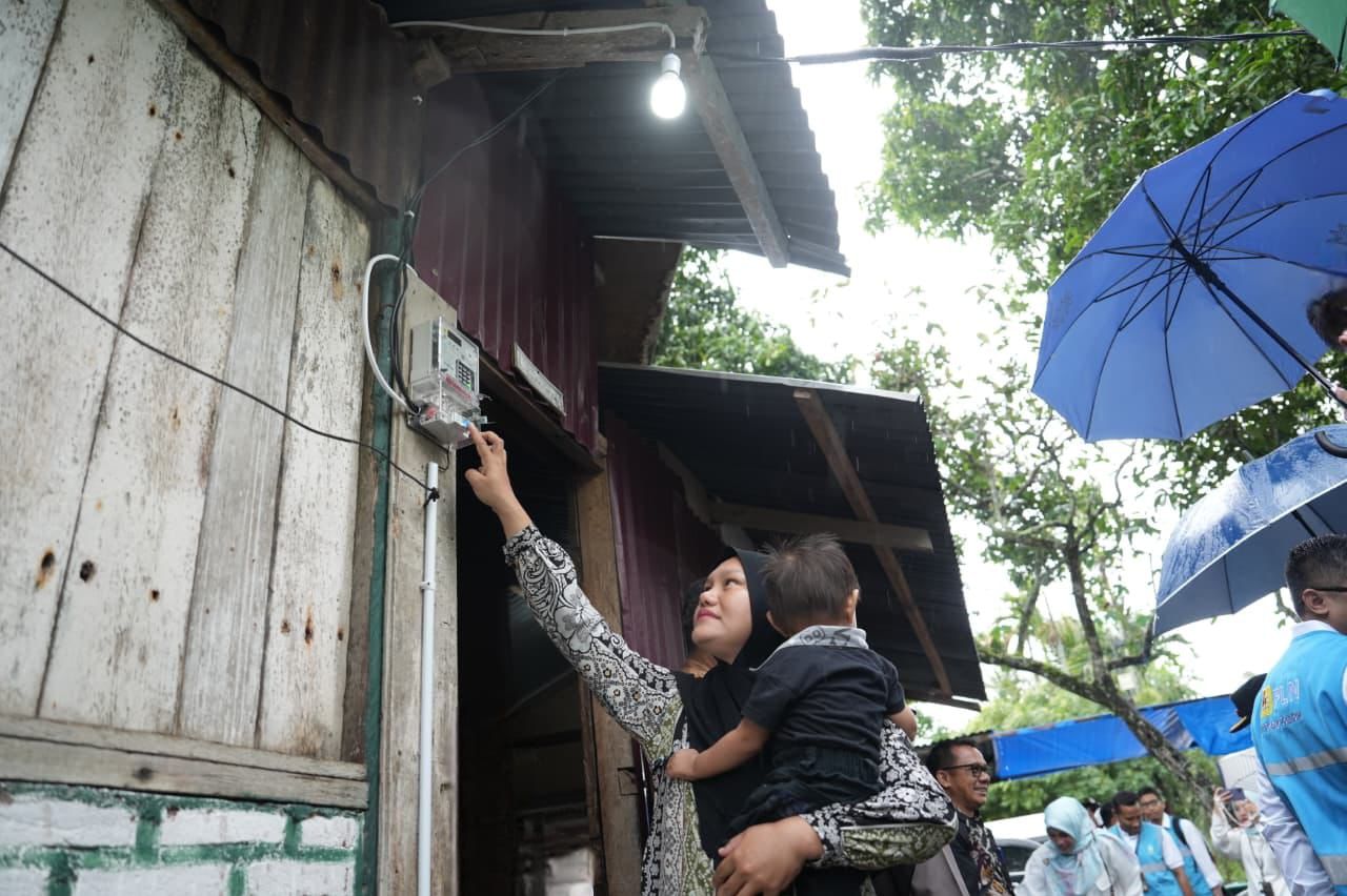 Salah satu penerima manfaat, Fitriani (38), saat menyalakan listrik di rumahnya untuk pertama kali. Bagi Fitriani, hadirnya listrik tak hanya membawa terang, tetapi juga harapan untuk kehidupan yang lebih baik. (Foto: PLN)