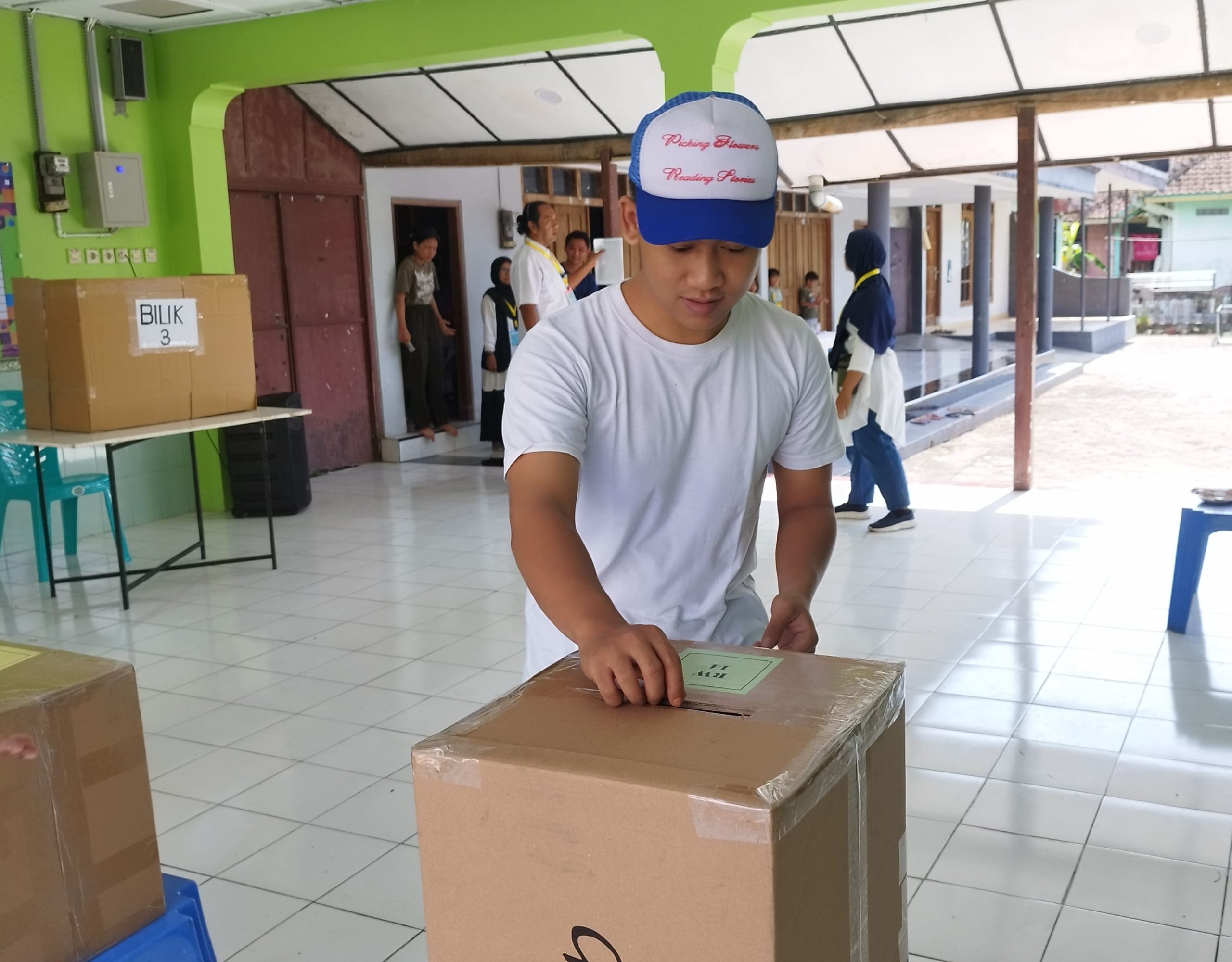 Salah satu pemilih memasukkan surat suara ke dalam kotak suara yang disediakan panitia pemilihan. (Foto: Serikat News)