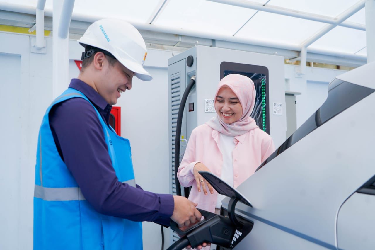 Ilustrasi pengguna electric vehicle dibantu oleh Petugas PLN ketika mengisi kendaraan listriknya di salah satu SPKLU. (Dok, PLN)