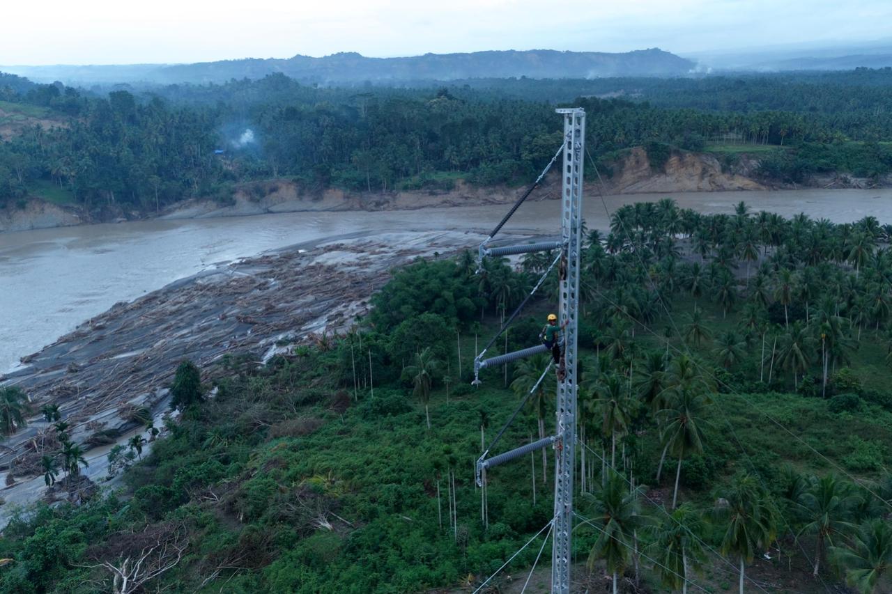 Petugas PLN ketika melakukan penyambungan kabel transmisi Saluran Udara Tegangan Tinggi (SUTT) 150 kilovolt (kV) Arun - Bireuen di atas emergency tower yang telah didirikan. (Foto: PLN) 